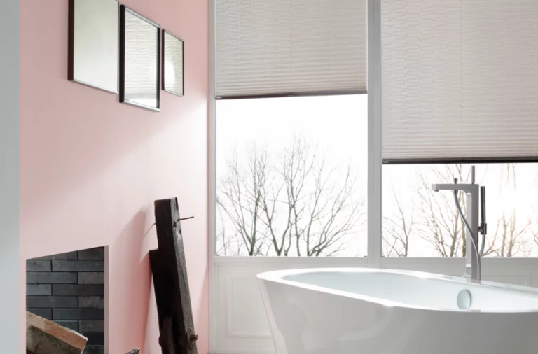 Bañera ovalada independiente de acero esmaltado en baño moderno con azulejos imitación madera y mucha luz natural.